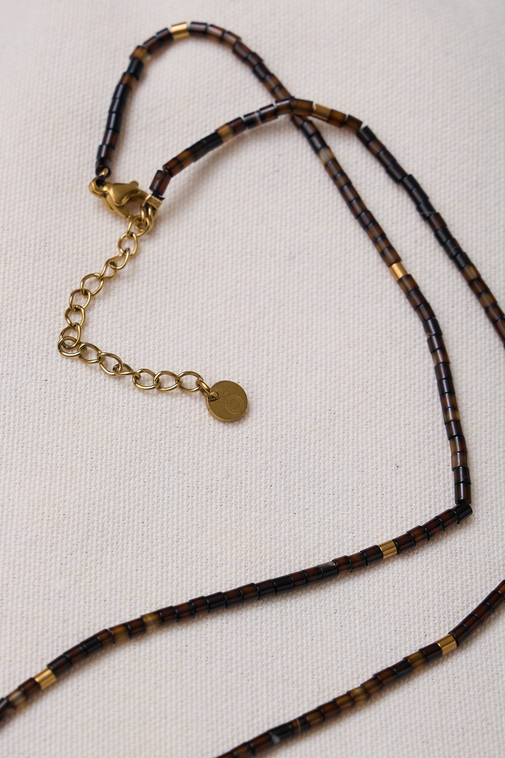 Stone Round Necklace - Dark Brown with small round beads and a gold-tone adjustable chain for a subtle, earthy touch.