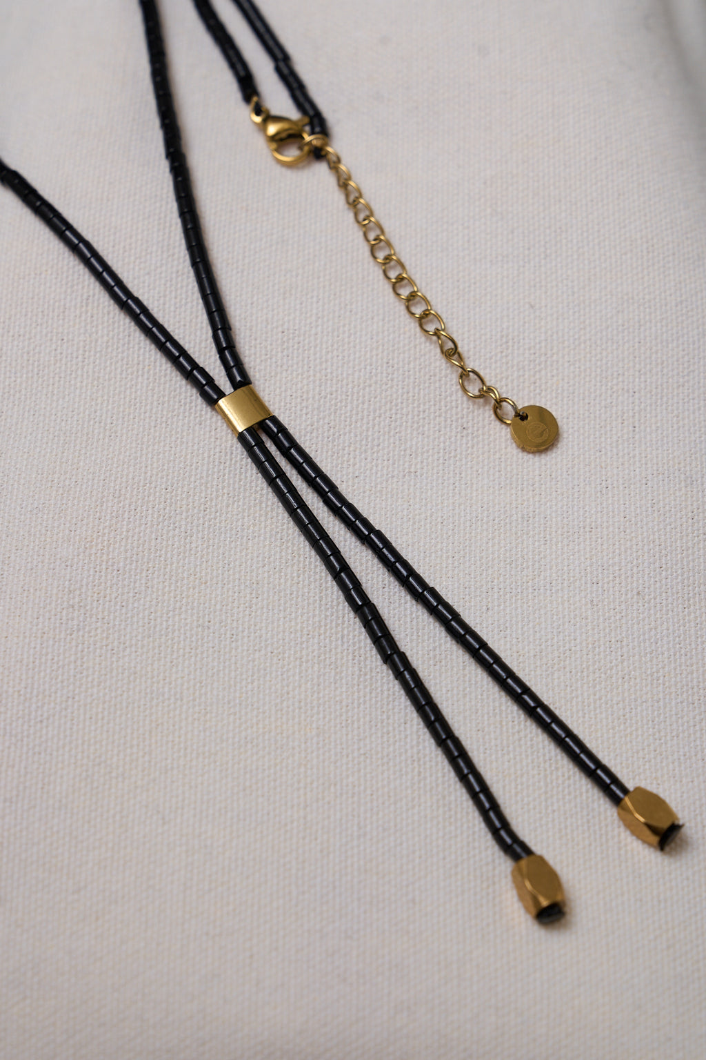 Stone Lariat Necklace - Black featuring delicate black beads with gold-tone accents and adjustable chain for a subtle, modern touch.