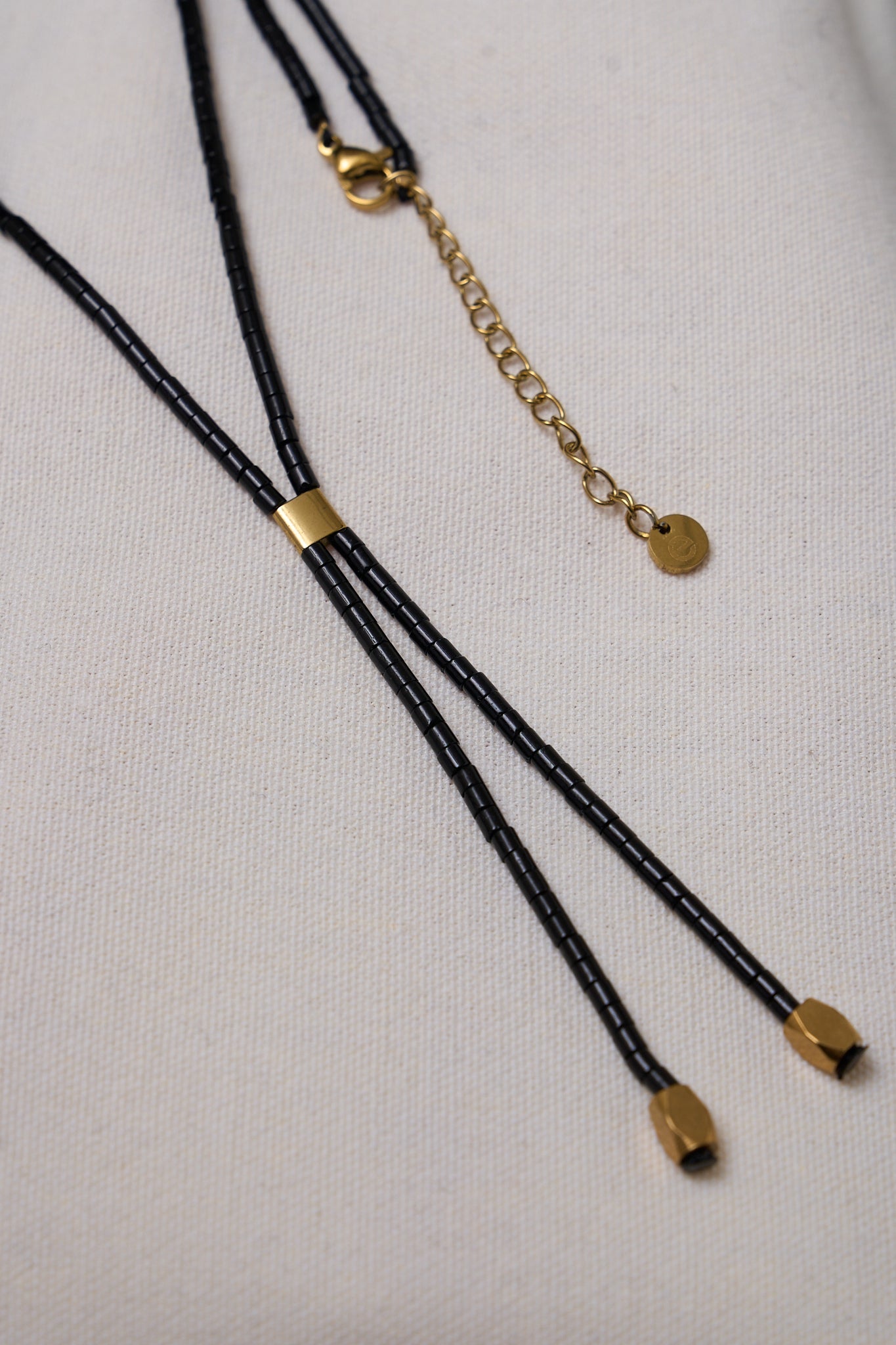 Stone Lariat Necklace - Black featuring delicate black beads with gold-tone accents and adjustable chain for a subtle, modern touch.