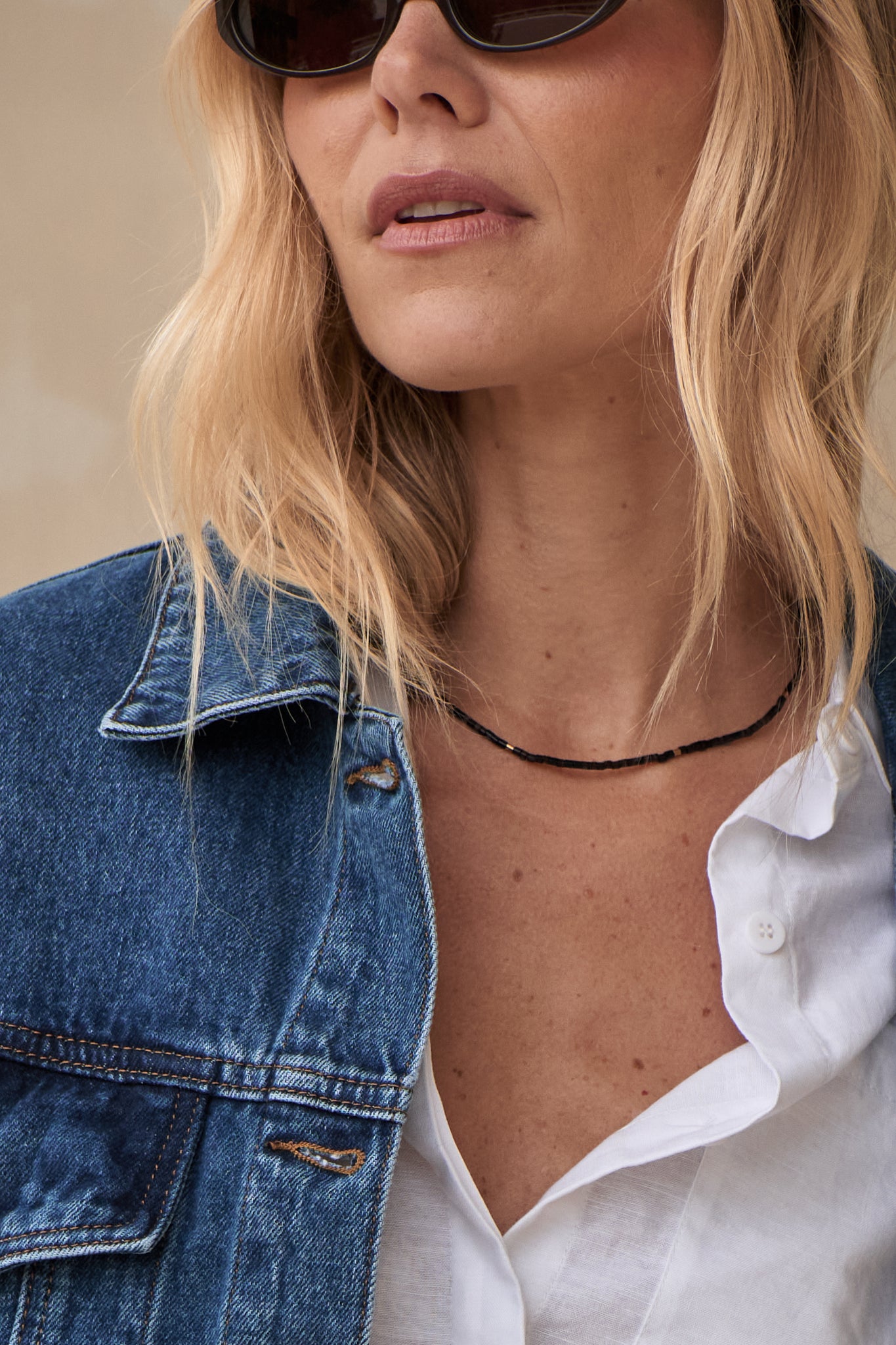 Stone Round Necklace - Black featuring small black rounded beads resting against the neckline for a minimalist touch.