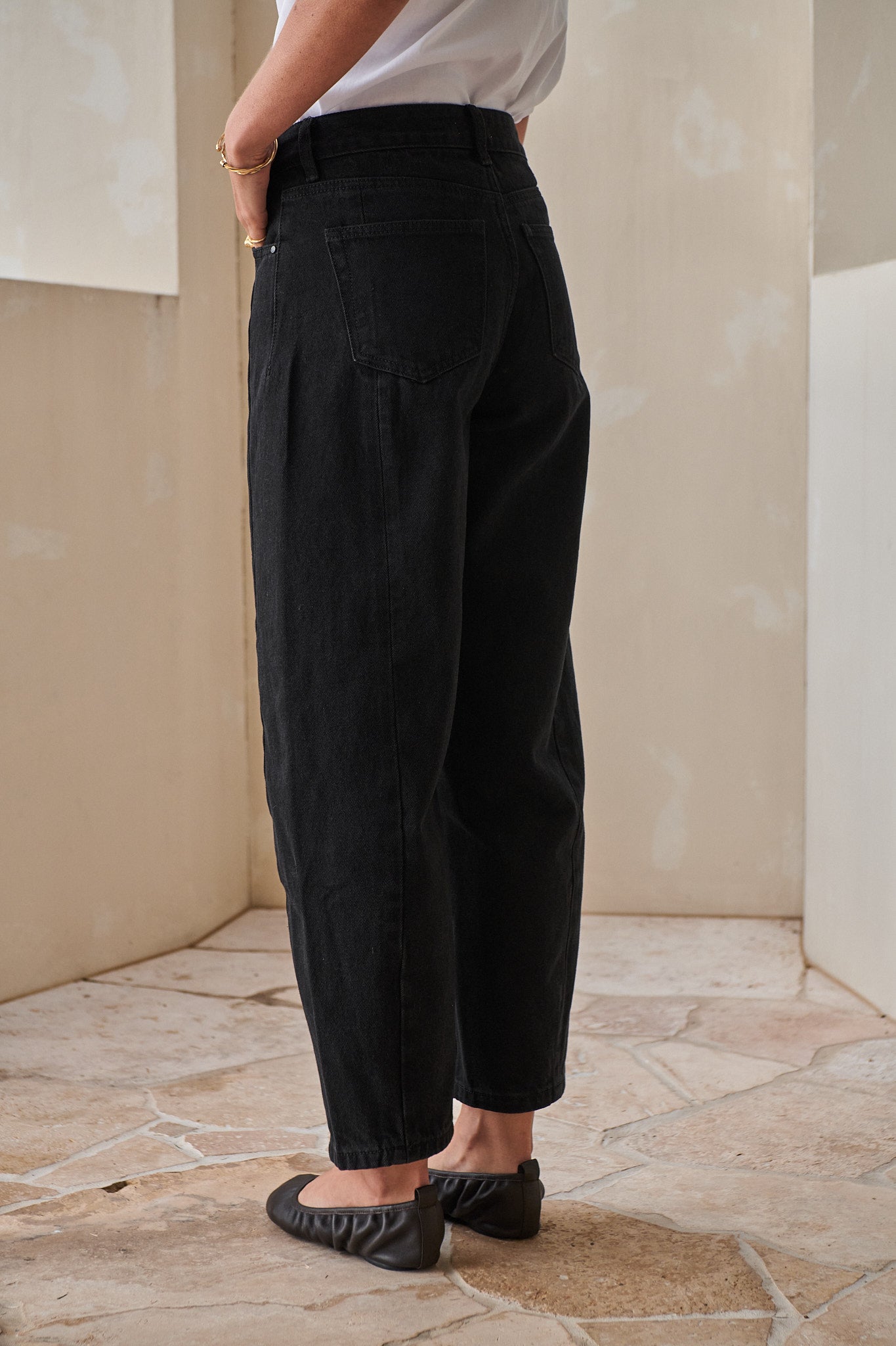 Mid Rise Barrel Jean - Black in rigid denim with a tapered leg and shaped seam for a flattering fit.