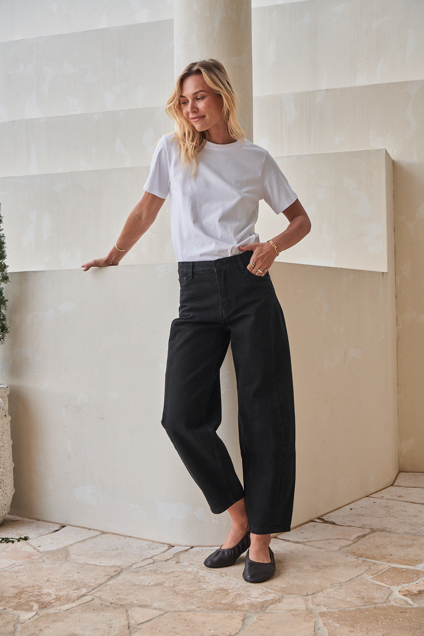 Mid Rise Barrel Jean - Black in rigid denim with a fitted hip and flared leg, holding its shape effortlessly.