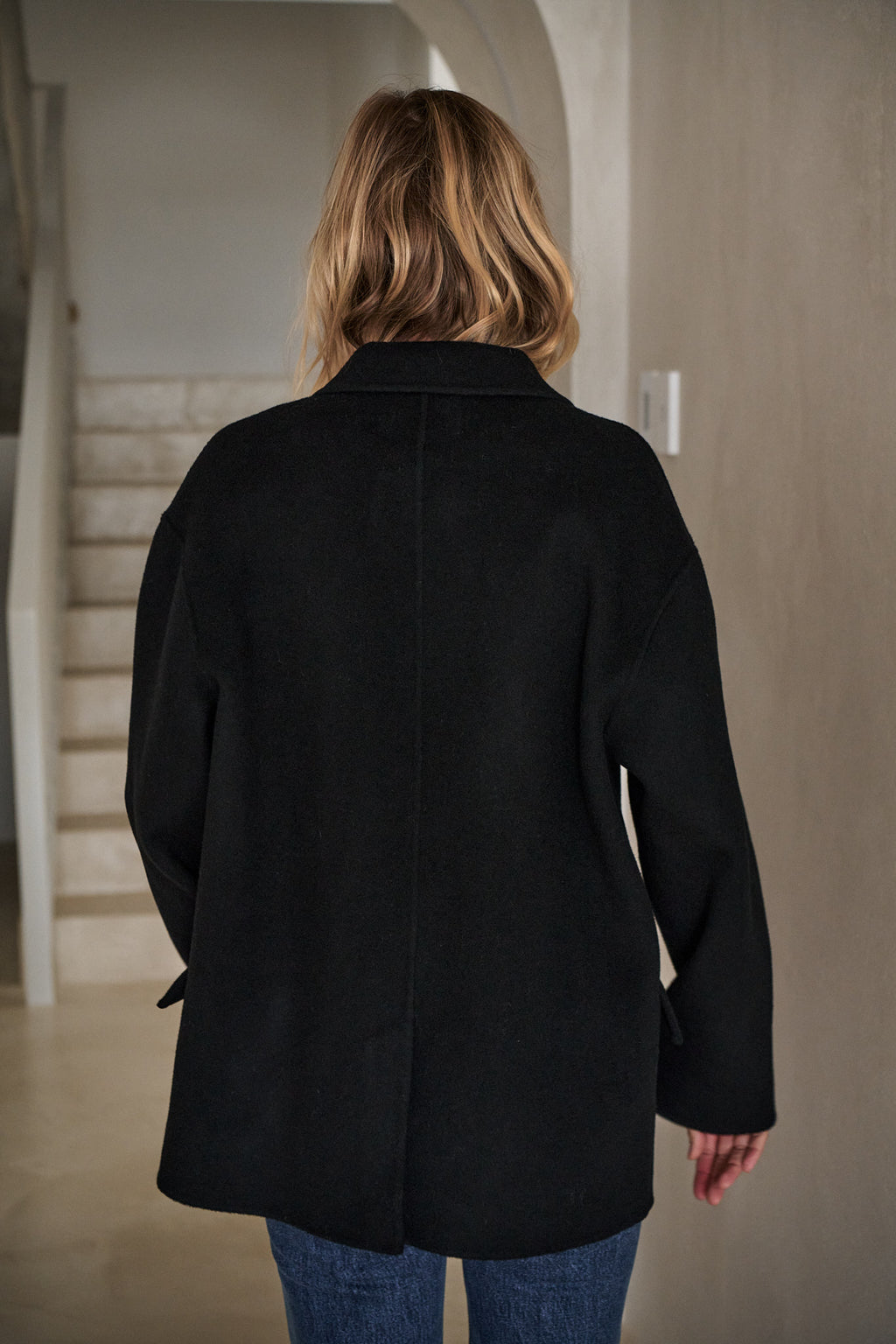 Double Breasted Wool Blazer - Black shown from the back, featuring a clean wool fabric and relaxed silhouette for everyday layering.