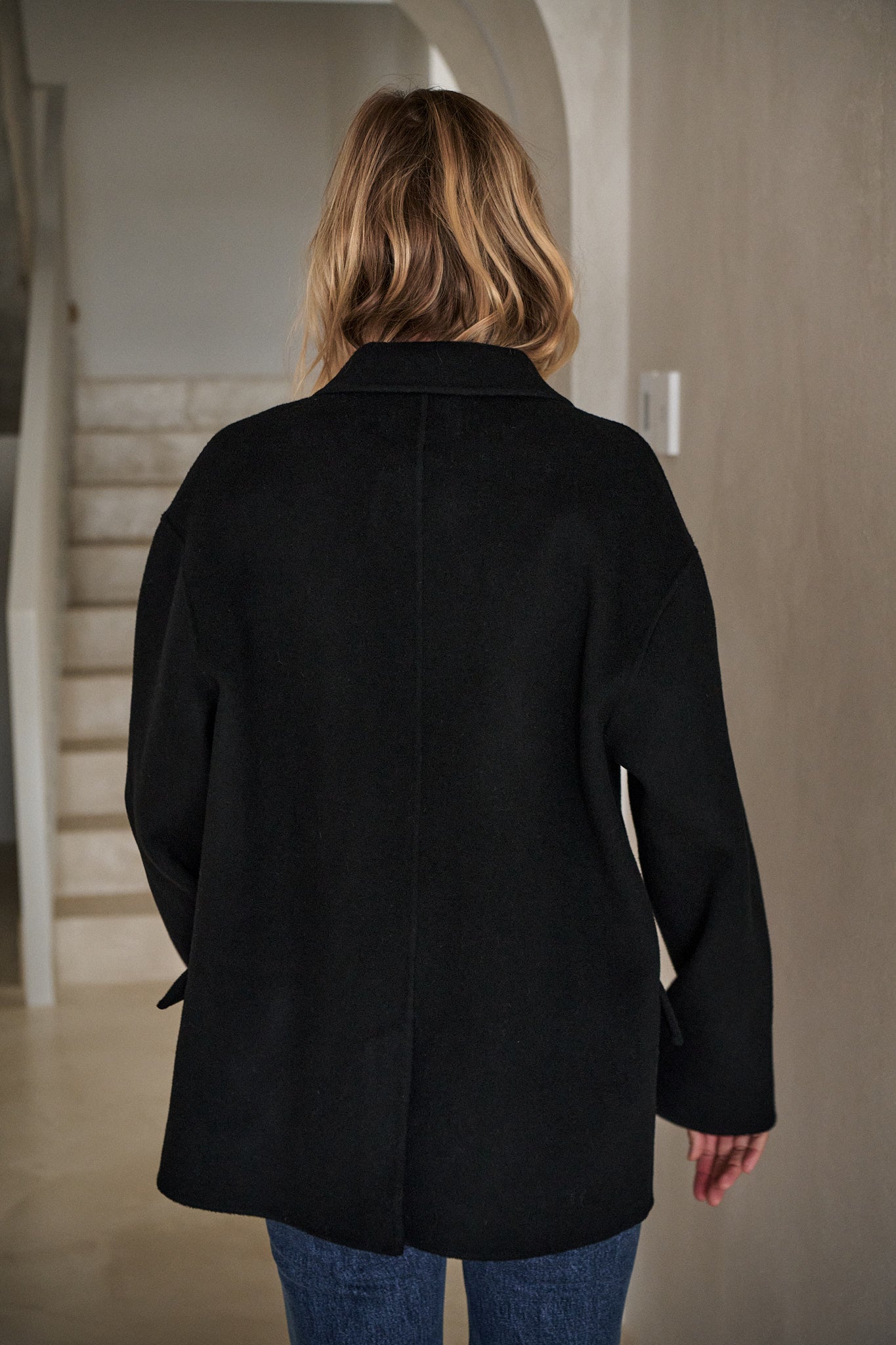 Double Breasted Wool Blazer - Black shown from the back, featuring a clean wool fabric and relaxed silhouette for everyday layering.