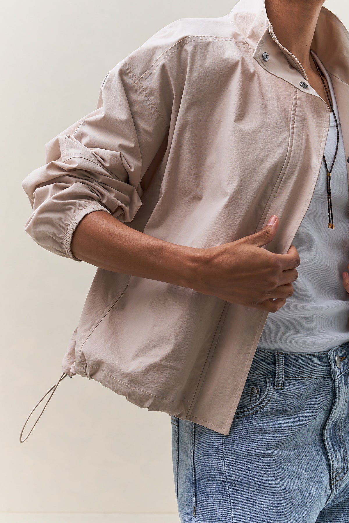 Nylon Track Jacket - Bone, a lightweight nylon track jacket with a stand collar and adjustable hem and waist