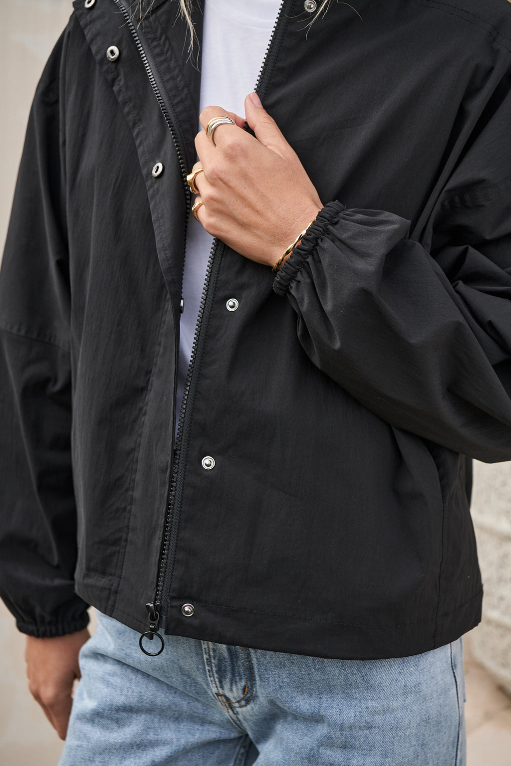 Nylon Track Jacket - Black featuring a lightweight nylon shell with elasticated cuffs and an adjustable hem for a tailored fit.