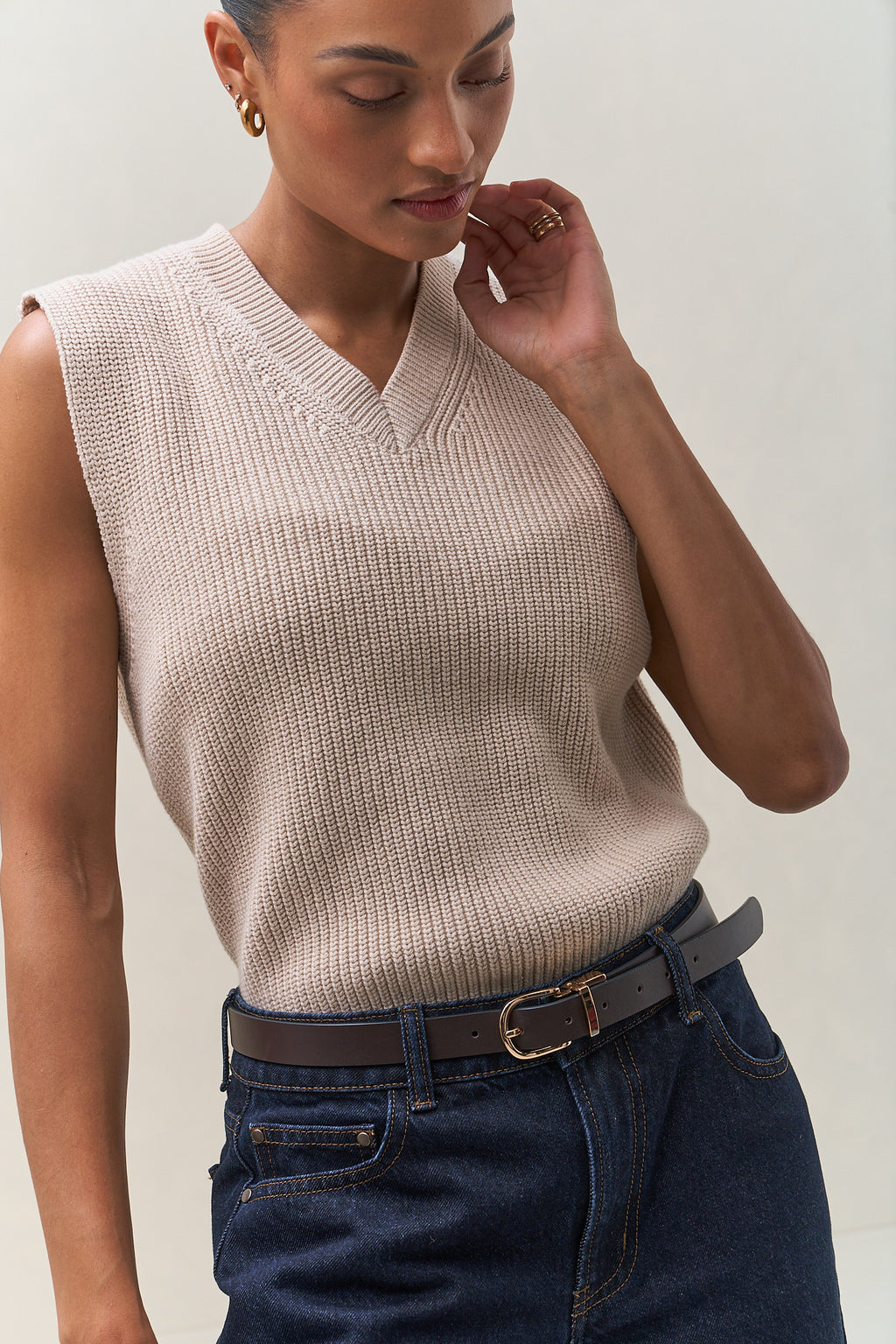 V-Neck Knit Vest in soft beige cotton with a cropped hem and textured knit, perfect for layering.